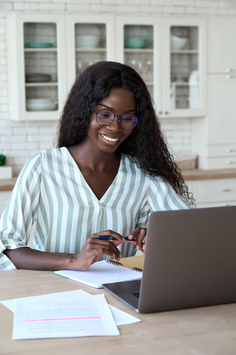 Young Happy Black Woman Student Learning at Home Watching Webinar.